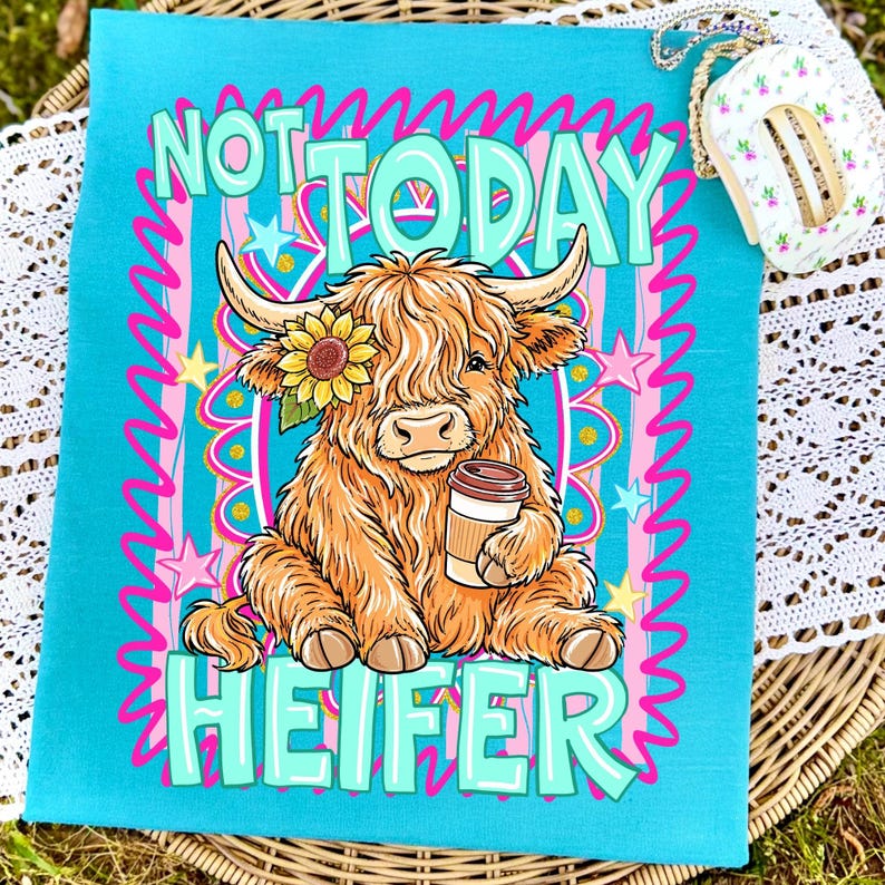 May include: A turquoise tea towel with the words "NOT TODAY HEIFER" in teal and pink. The towel features a cartoon illustration of a Highland cow with a sunflower and a coffee cup. The cow is brown and tan with long shaggy hair.