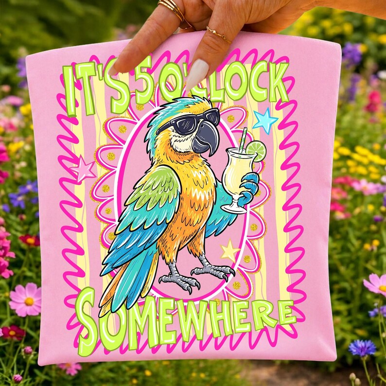 May include: Pink square pillow with a cartoon parrot wearing sunglasses and holding a cocktail. The text "IT'S 5 O'CLOCK SOMEWHERE" is in green and yellow. The parrot is yellow, blue, and orange.