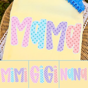 Puede incluir: Una camiseta amarilla clara con la palabra "Mama" en letras grandes y coloridas con lunares. Las letras son rosas, azules y moradas. Debajo hay tres im&aacute;genes m&aacute;s peque&ntilde;as con las palabras "Mimi Gigi Nana" en estilos similares.