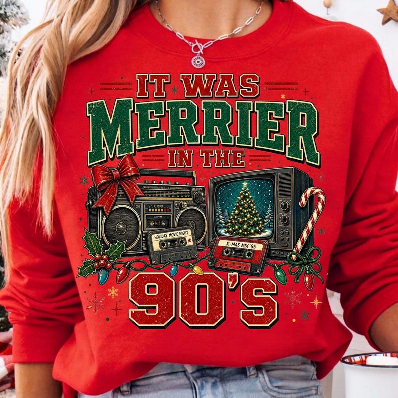 Może przedstawiać: Czerwona bluza z długim rękawem z nadrukiem graficznym i napisem IT WAS MERRIER IN THE 90'S. Wz&oacute;r przedstawia boombox, telewizor z choinką, dwie kasety magnetofonowe, czerwoną kokardę, ostrokrzew oraz laskę cukrową.