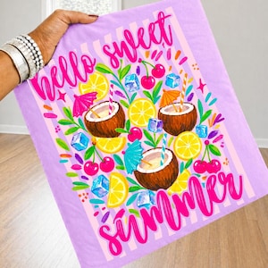 May include: A light purple fabric featuring a pink striped background and the text Hello Sweet Summer. The design includes illustrations of three coconut halves with straws and cocktail umbrellas, yellow lemon slices, red cherries, and blue ice cubes.