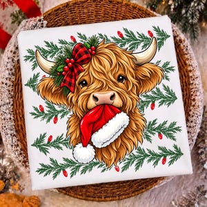 May include: A white square textile featuring a graphic of a fluffy brown Highland cow with long horns. The cow wears a red and black buffalo plaid bow with holly berries and holds a red and white Santa hat in its mouth, surrounded by pine branches.