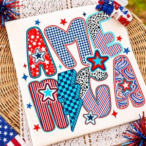 May include: A white fabric transfer featuring the word AMERICA in large, stylized letters with various red, white, and blue patterns including stars, stripes, checkers, and swirls. A blue lightning bolt replaces the letter I, and small stars surround the text.