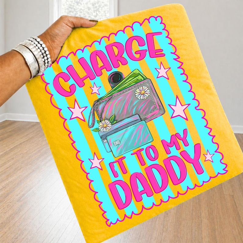 May include: A yellow blanket featuring a bright blue scalloped border with vertical stripes and pink stars. The center graphic shows a wallet and credit card with the text "CHARGE IT TO MY DADDY" in bold pink letters, accented by small white flowers.