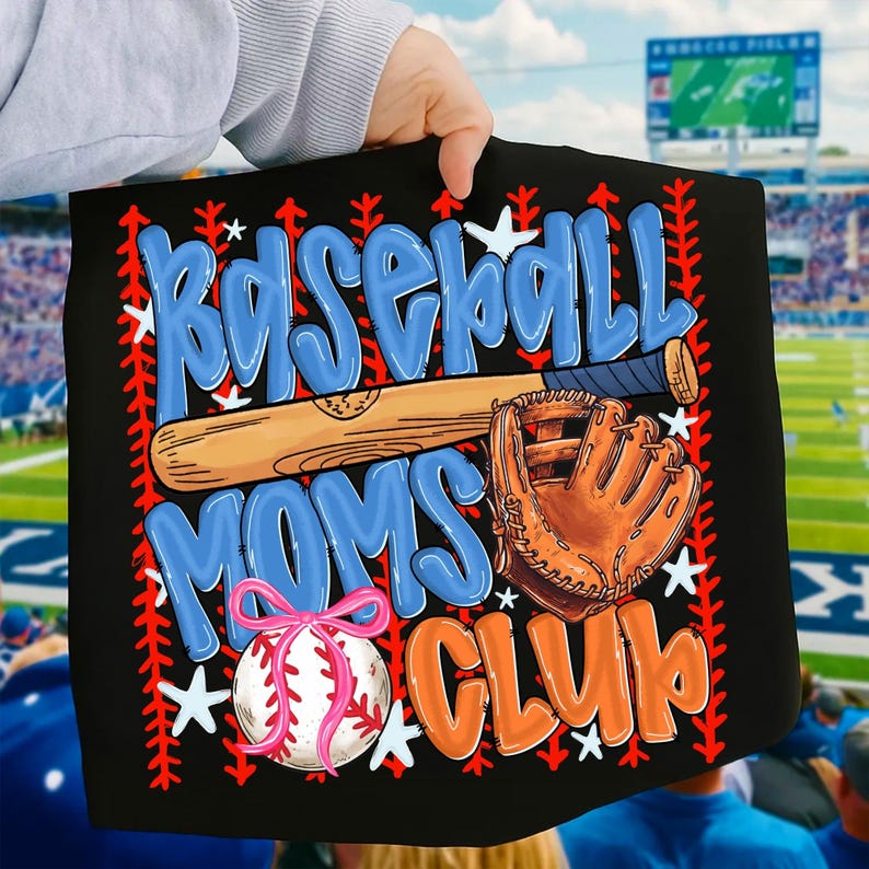 May include: Black baseball-themed graphic with the words "Baseball Moms Club" in blue and orange. A baseball bat, glove, and baseball with a pink bow are also featured. White stars and red stitching accents complete the design.
