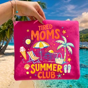 May include: A hot pink zippered pouch with the words "TIRED MOMS SUMMER CLUB" in orange and yellow. The design includes beach-themed illustrations such as a palm tree, ice cream cone, beach chair, and umbrella.