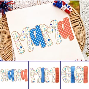 May include: A white fabric surface featuring the word MAMA in large letters. The letters M and A have a floral pattern with blue, purple, and green flowers on a white background, while the M and A have blue and red polka dot patterns.