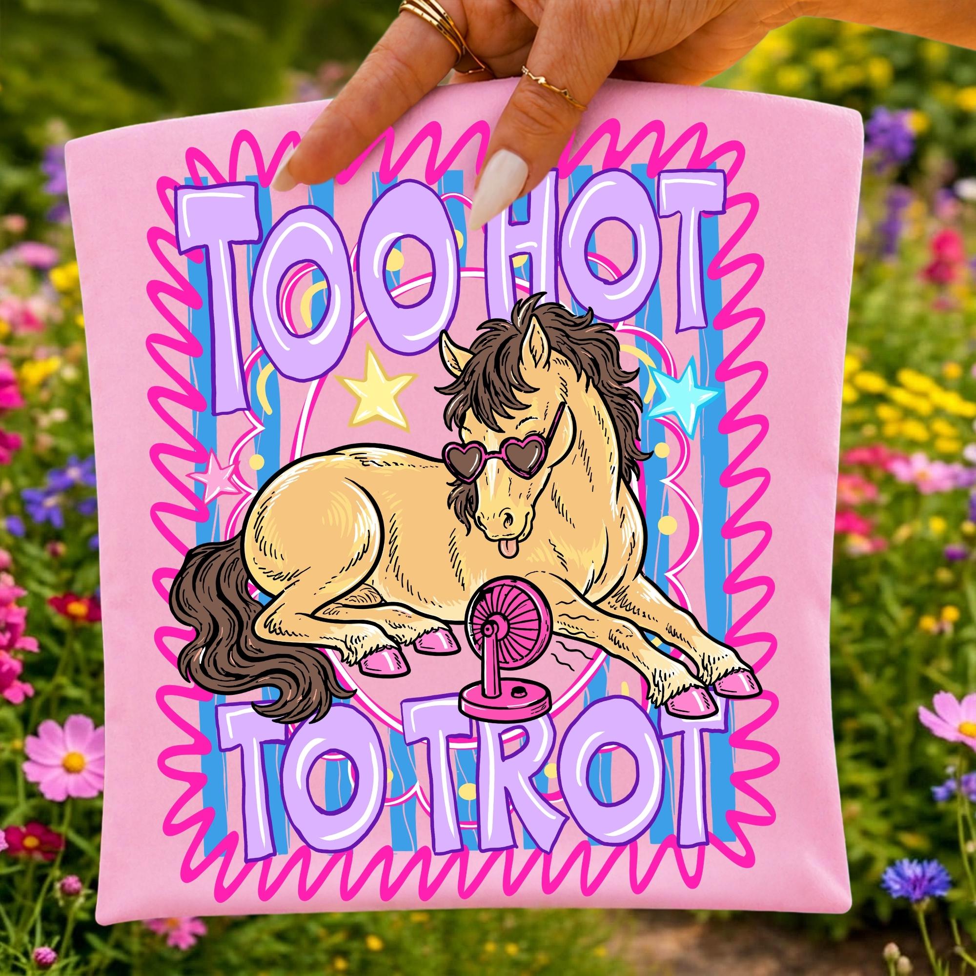 May include: A light pink fabric square featuring a graphic of a tan horse wearing heart-shaped sunglasses, lying down next to a small pink fan. The text reads TOO HOT TO TROT in large purple letters, surrounded by a blue striped background and pink border.