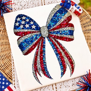 May include: A decorative bow covered in sparkling red, white, and blue rhinestones. The left loop features a pattern of white stars on a blue background, while the rest of the bow displays alternating stripes of red, blue, and silver crystals.