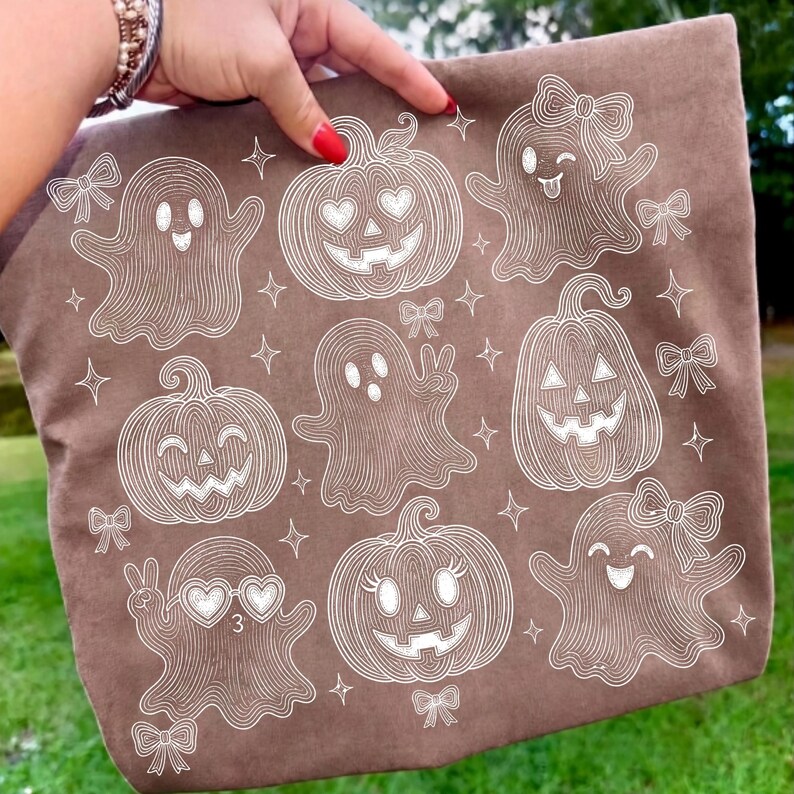 Puede incluir: Un bolso de tela marr&oacute;n con un patr&oacute;n de l&iacute;neas blancas de varios fantasmas y calabazas. Los fantasmas tienen diferentes expresiones, algunos llevan lazos o gafas de sol en forma de coraz&oacute;n, mientras que las calabazas tienen caras talladas.