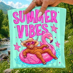 Pu&ograve; includere: Un quadrato di tessuto verde menta chiaro con la scritta rosa acceso SUMMER VIBES. L'illustrazione raffigura una mucca Highland marrone con cappello di paglia e occhiali da sole rosa, adagiata su un salvagente fenicottero rosa tra stelle rosa.