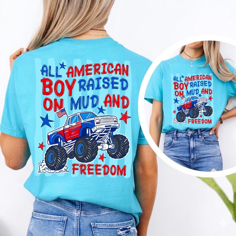 May include: A bright turquoise t-shirt featuring a graphic of a red, white, and blue monster truck with an American flag. The text reads: ALL AMERICAN BOY RAISED ON MUD AND FREEDOM. The design includes red and blue stars on a light blue striped background.