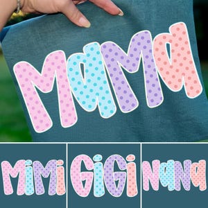 Puede incluir: Tela de color verde azulado con la palabra "MAMA" en letras grandes y coloridas con lunares. Las letras son rosas, azules y moradas con contornos blancos. Debajo hay tres dise&ntilde;os adicionales con las palabras "MIMI", "GIGI" y "NANA" en estilos similares.