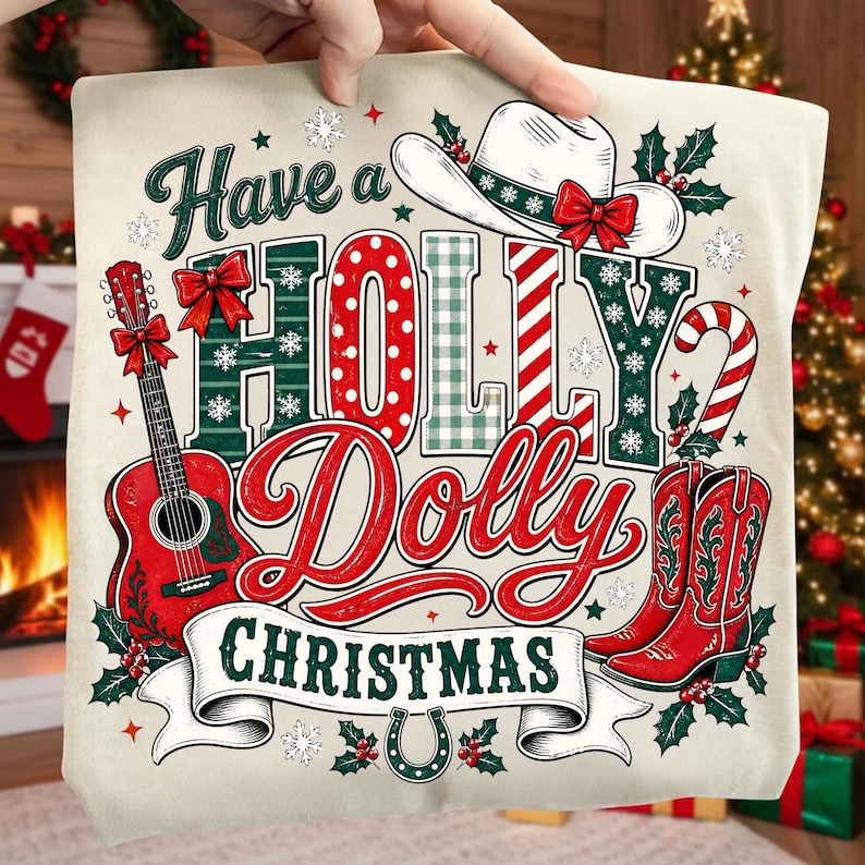May include: A cream-colored fabric item featuring a graphic print with the text Have a Holly Dolly Christmas. The design includes a white cowboy hat with a red bow, a red acoustic guitar, red cowboy boots, a candy cane, and holly leaves.