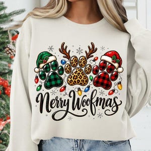 Pu&ograve; includere: Una felpa girocollo color crema con una grafica di tre impronte di zampe. La zampa sinistra &egrave; a quadri verdi con un cappello da Babbo Natale, quella centrale ha macchie di leopardo e corna di renna, la destra &egrave; a quadri rossi con cappello. Scritta Merry Woofmas.