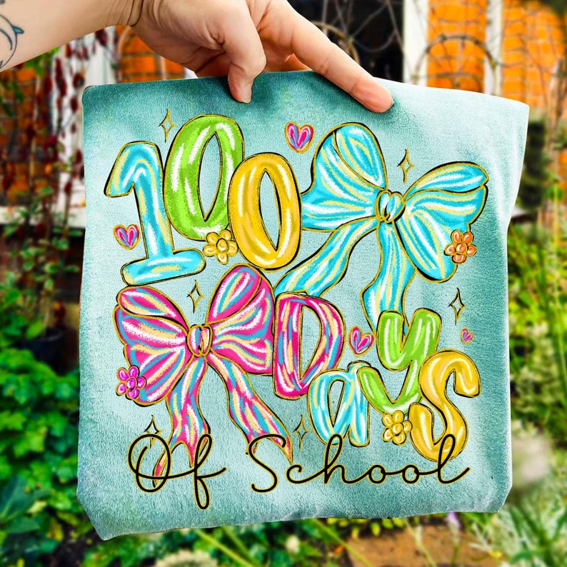 Op de afbeelding: Een turquoise vierkant met de tekst "100 Days of School" in kleurrijke, grillige letters. Het ontwerp bevat grote, decoratieve strikken in roze, blauwe en gele tinten, met bloemaccenten en harten.