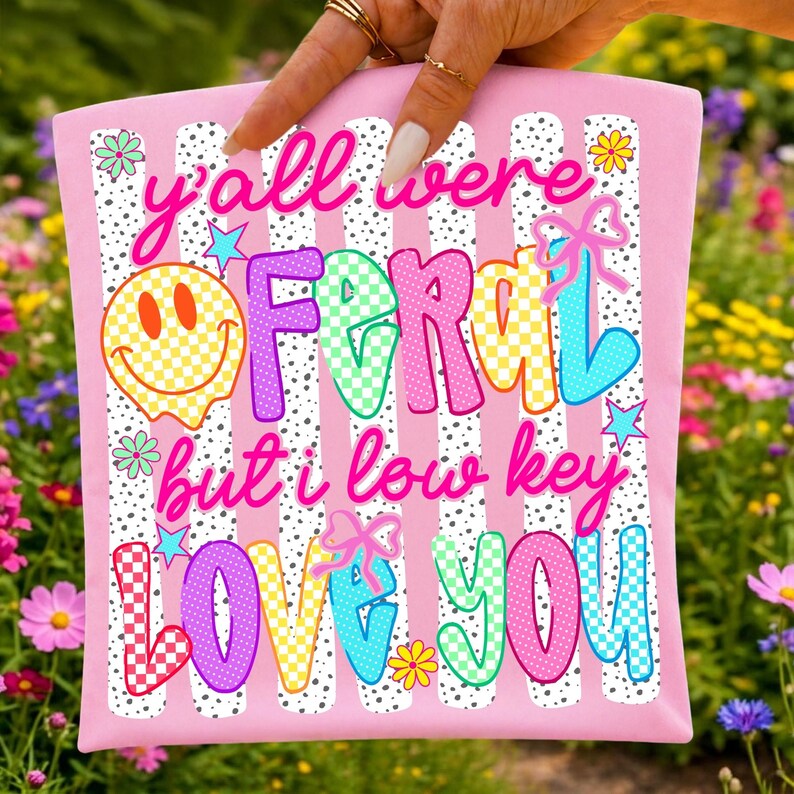 Close-up of the Y'all Were Feral funny teacher PNG with smiley face and bow graphics.