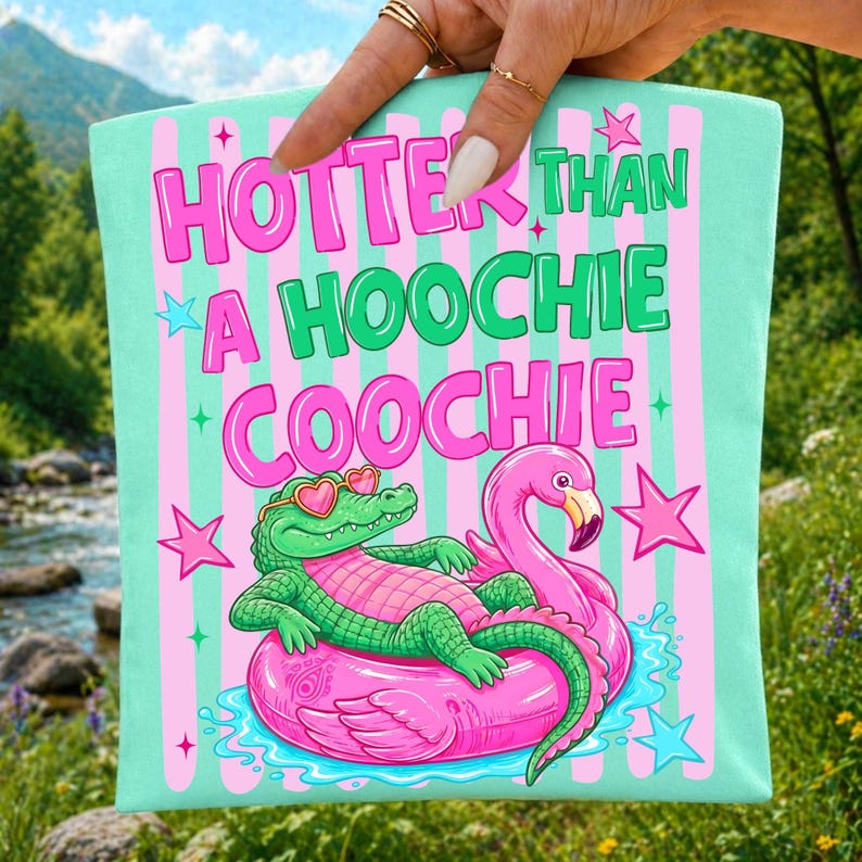 Vibrant 'Hotter Than A Hoochie Coochie' coquette alligator PNG design with pink bow on a white background, perfect for sublimation projects.