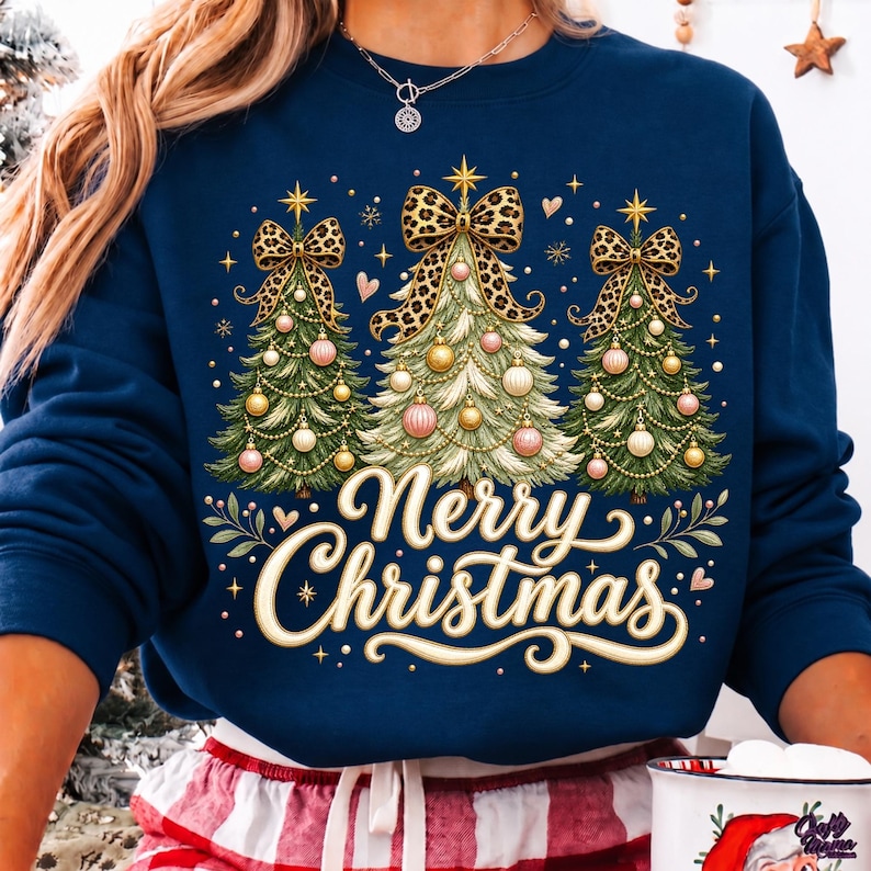 Peut inclure: Un sweat-shirt bleu marine &agrave; manches longues orn&eacute; de trois sapins de No&euml;l d&eacute;cor&eacute;s de boules dor&eacute;es et roses, surmont&eacute;s de grands n&oelig;uds &agrave; motif l&eacute;opard. Le texte Merry Christmas est &eacute;crit en lettres cursives couleur cr&egrave;me en dessous.
