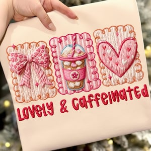 Puede incluir: Tela beige claro con diseños bordados. Presenta un lazo rosa, una taza de café con malvaviscos y un corazón. El texto "Lovely & Caffeinated" está bordado en rojo. El diseño tiene un borde festoneado.