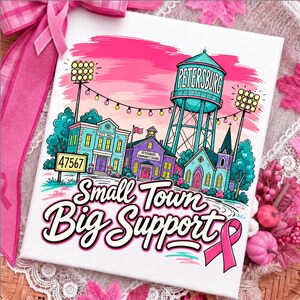May include: A white rectangular sign featuring a colorful illustration of a small town with a water tower labeled Petersburg, a city hall, a community school, and a church. The text reads 47567 and Small Town Big Support with a pink ribbon.