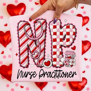 May include: Pink Nurse Practitioner t-shirt with the letters "NP" in red and white patterns, a stethoscope, and a coffee cup and syringe graphic. The words "Nurse Practitioner" are written in black script.