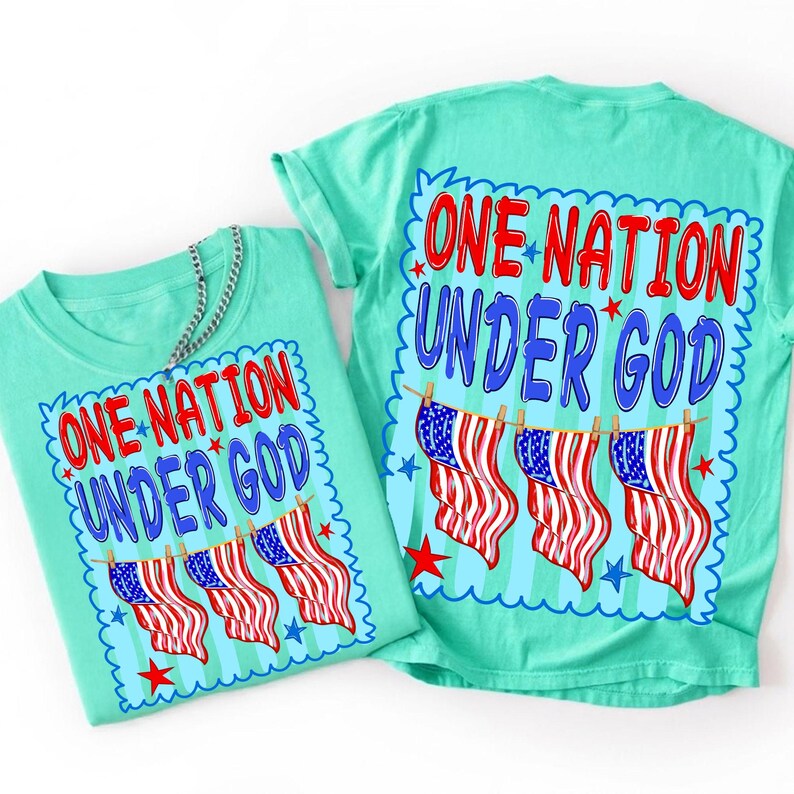 May include: A light mint green t-shirt featuring a graphic print with the text ONE NATION UNDER GOD in red and blue letters. Below the text, three American flags hang from a clothesline, surrounded by small red and blue stars on a striped background.