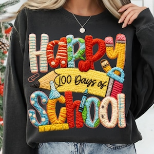 Peut inclure: Sweat-shirt gris foncé avec texte brodé coloré et graphiques sur le thème de l'école. Le motif comprend les mots "Happy 100 Days of School" avec un crayon, une pomme et d'autres fournitures scolaires. Les lettres sont de couleurs variées.