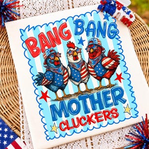 May include: A white t-shirt featuring a graphic of three chickens wearing patriotic American flag-themed hats, star-spangled vests, and star-shaped sunglasses. The text reads BANG BANG MOTHER CLUCKERS in red and blue against a light blue striped background.