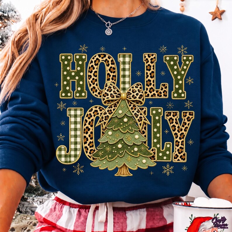 May include: A navy blue crewneck sweatshirt featuring the text HOLLY JOLLY in a mix of green polka dot, green plaid, and leopard print patterns. A central green Christmas tree graphic with a leopard print bow sits between the words.