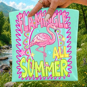 May include: A light mint green fabric pouch featuring a central pink flamingo illustration inside a decorative oval frame. The text FLAMINGLE is printed in pink above the flamingo, and ALL SUMMER is printed in lime green below the flamingo.