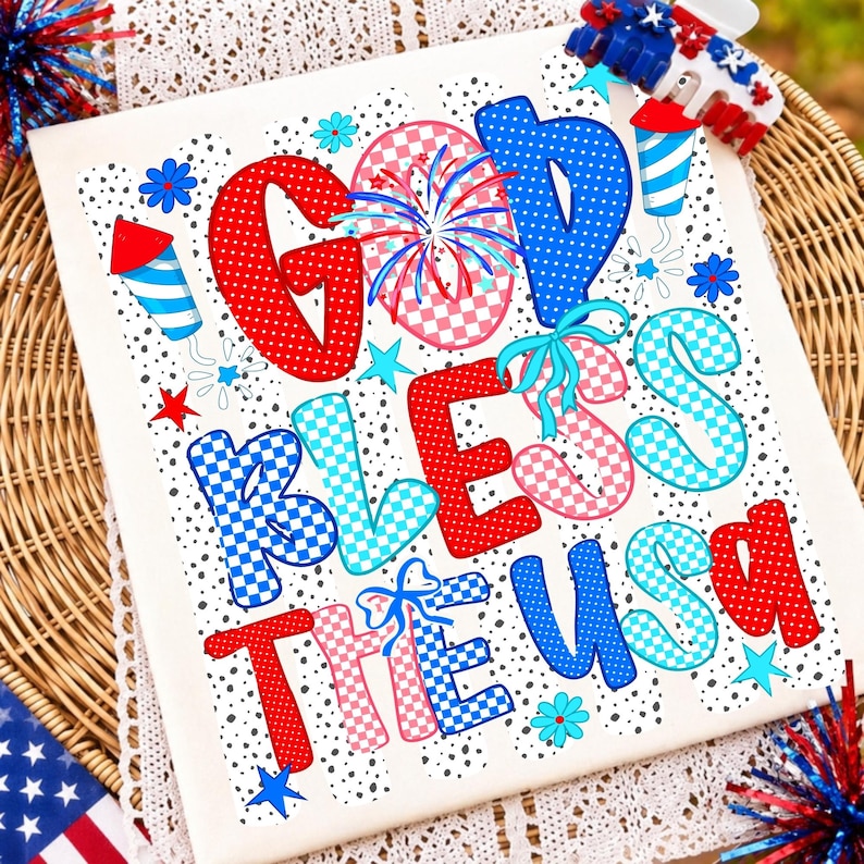 K&ouml;nnte beinhalten: Ein wei&szlig;es rechteckiges Schild mit dem Text GOD BLESS THE USA in roten, blauen und rosafarbenen Karomustern und Punkten. Das Design enth&auml;lt Feuerwerksillustrationen, kleine Sterne und Blumen sowie eine patriotische Haarspange an der Ecke.
