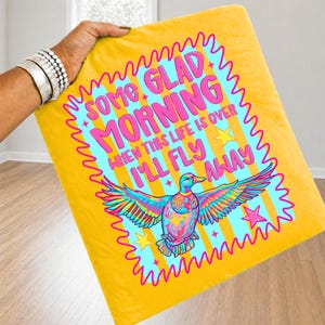 Pu&ograve; includere: Una federa quadrata gialla con una grafica vivace di un'anatra con le ali spiegate. Il testo recita SOME GLAD MORNING WHEN THIS LIFE IS OVER I'LL FLY AWAY. Il design include stelle e strisce nei colori rosa, blu e giallo.