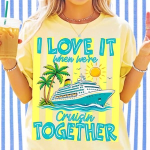 K&ouml;nnte beinhalten: Ein hellgelbes T-Shirt mit einer Grafik eines Kreuzfahrtschiffs auf blauem Wasser, Palmen und einer gelben Sonne. Der Text I LOVE IT when we're Cruisin TOGETHER ist in leuchtendem Blau und Gelb vor einem vertikal gestreiften Hintergrund.