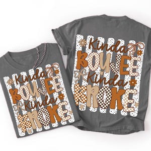 Pode incluir: Duas camisetas cinza-chumbo com estampa gr&aacute;fica de listras verticais brancas e pontos pretos. O texto Kinda BOUJEE Kinda BROKE est&aacute; em marrom, bege e xadrez, decorado com pequenas flores marrons, estrelas e la&ccedil;os de fita.