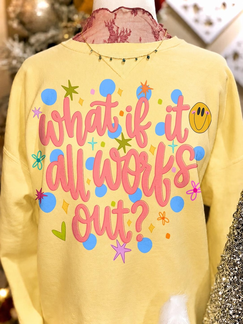 Retro daisy smiley face 'What If It All Works Out' PNG design on a white t-shirt mockup, showcasing preppy positivity.