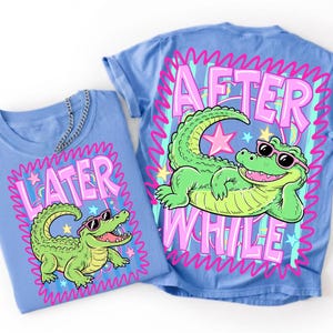 Peut inclure: Un t-shirt bleu clair avec un motif d'alligator vert portant des lunettes de soleil roses. Le texte "LATER" est imprim&eacute; en grandes lettres roses au-dessus de l'alligator. Un second t-shirt bleu affiche le texte "AFTER WHILE" avec un alligator.