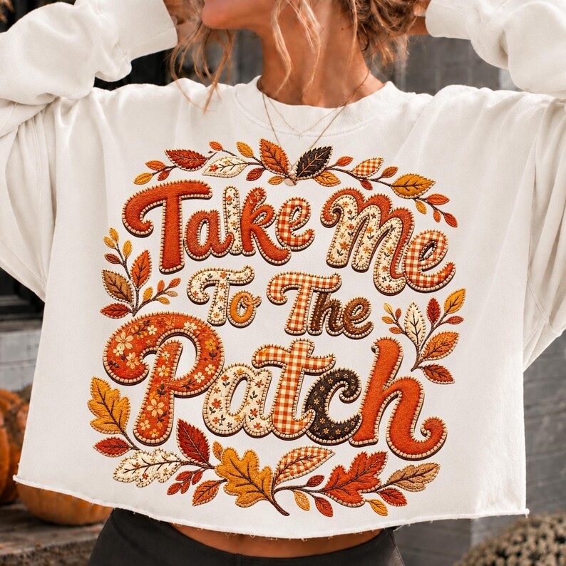 May include: A white long-sleeve sweatshirt featuring the text Take Me To The Patch in large, stylized orange and brown letters with plaid and floral patterns. The design is surrounded by a decorative border of various autumn-colored leaves.