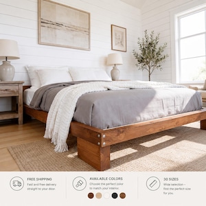 Pode incluir: Uma estrutura de cama baixa de madeira com acabamento castanho natural e parafusos metálicos visíveis nos cantos. A cama está coberta com uma capa de edredão cinzenta lisa e uma manta branca texturizada sobre o fundo do colchão.