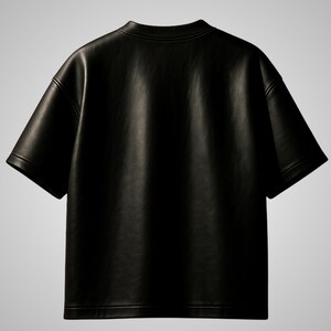 May include: A black, short-sleeved t-shirt made of a leather-like material. The shirt has a crew neck and a relaxed fit. The image shows the back of the shirt, highlighting its smooth texture and simple design. The garment is suitable for casual wear.