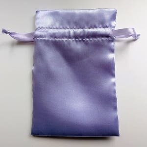 May include: A lavender satin drawstring pouch with a white cord.