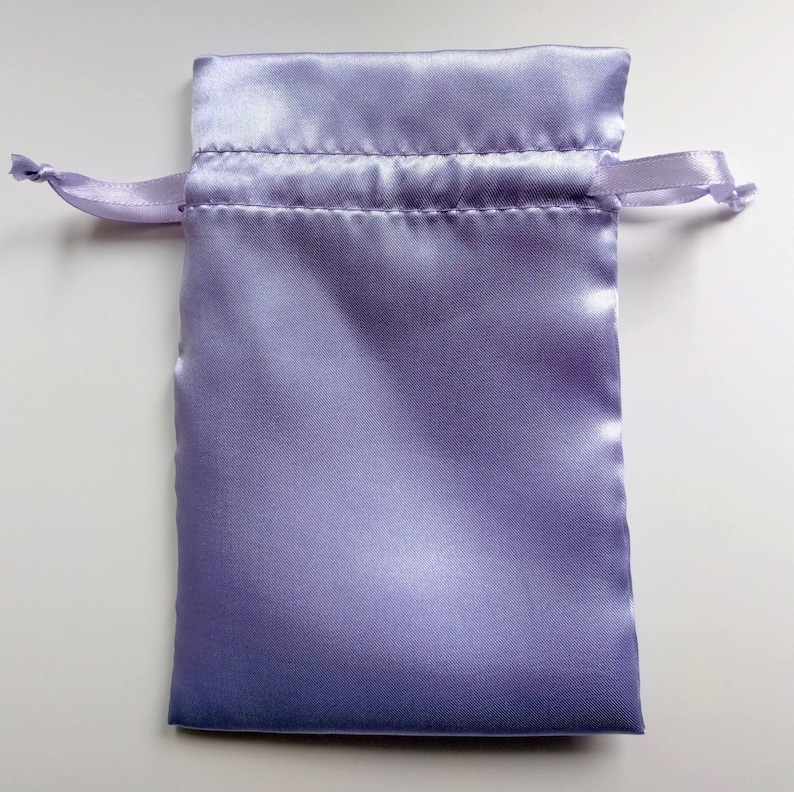 May include: A lavender satin drawstring pouch with a white cord.