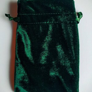 May include: A dark green velvet drawstring pouch with a satin ribbon tie.