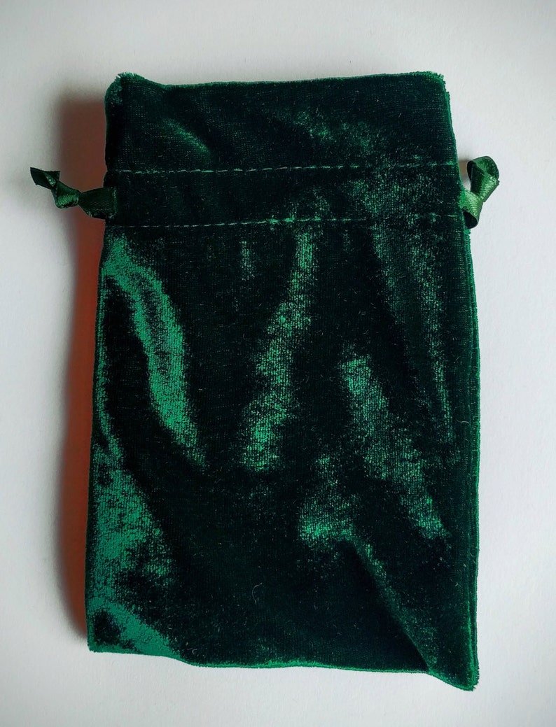 May include: A dark green velvet drawstring pouch with a satin ribbon tie.