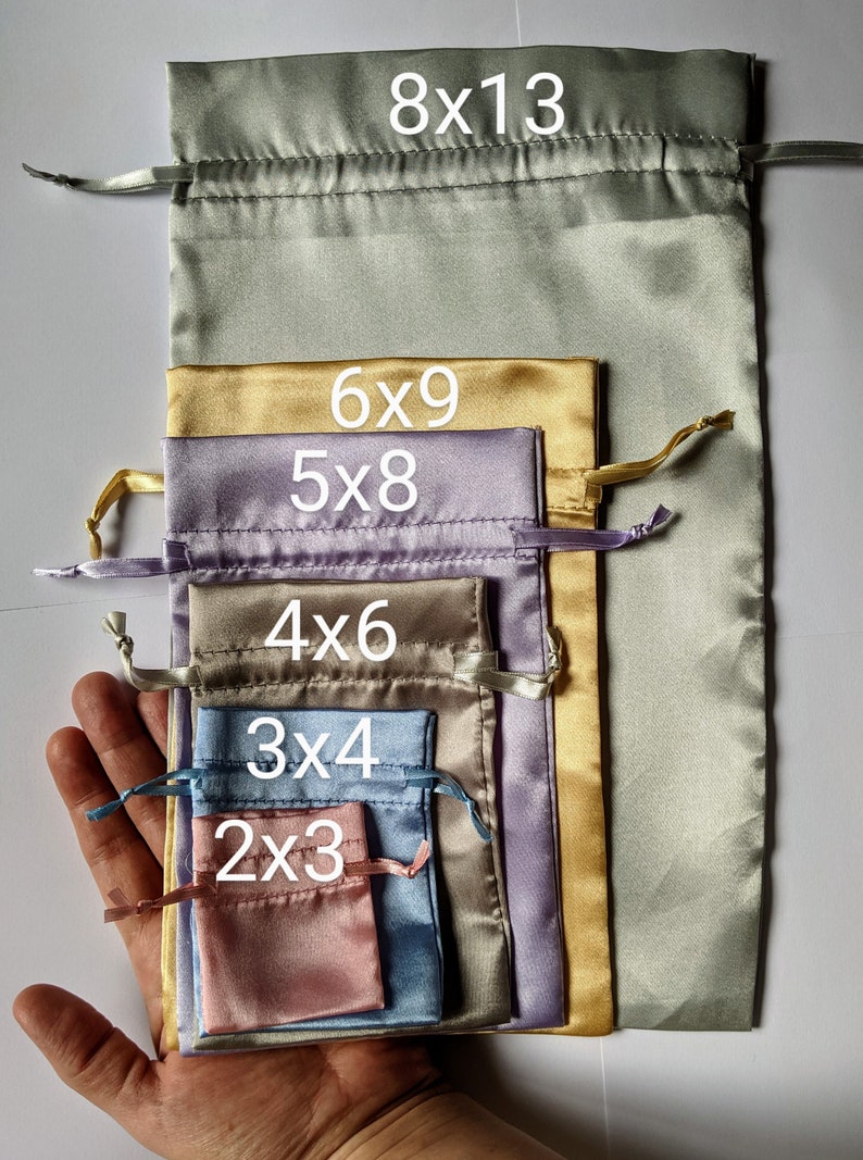 May include: Set of 6 satin drawstring bags in various sizes and colors, including green, gold, purple, brown, blue, and pink. The bags are labeled with their dimensions: 8x13, 6x9, 5x8, 4x6, 3x4, and 2x3.