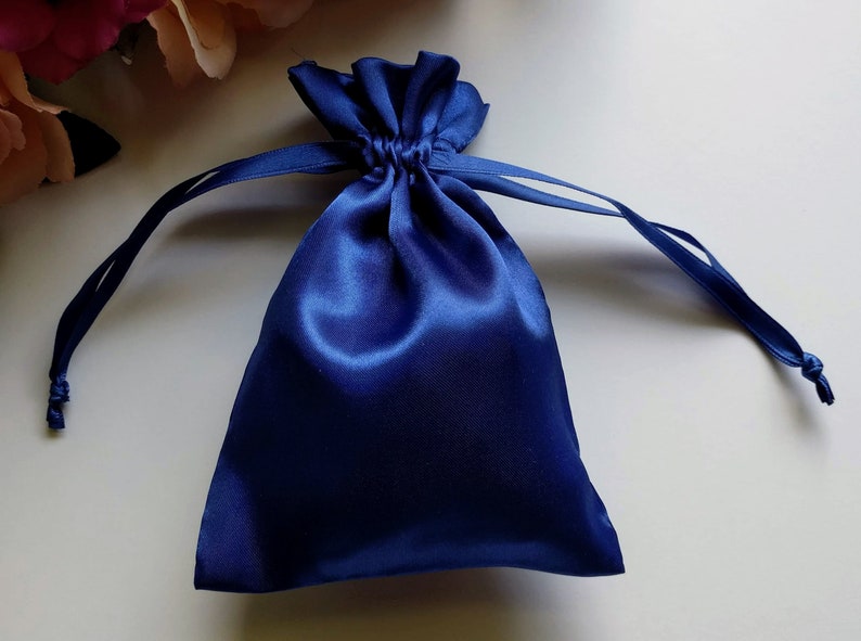 May include: A royal blue satin drawstring bag with a gathered top and a long cord.