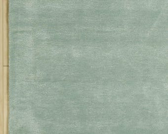 May include: A solid light sage green area rug with a dense, short-pile texture. The rug features a uniform color throughout, showcasing a soft, matte finish across its rectangular surface, providing a consistent and neutral appearance for floor coverage.
