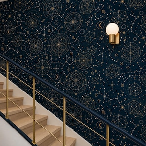 Pode incluir: Papel de parede azul-marinho escuro com um padrão repetitivo de motivos celestiais dourados, incluindo signos do zodíaco, mapas estelares geométricos e luas crescentes. Uma luminária de parede moderna com cúpula de vidro branco está montada.