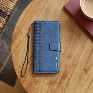 May include: A blue phone case with a textured diamond pattern on the left side and a magnetic clasp. The case has a wrist strap and the text "LSZSHOP" is printed on the front.