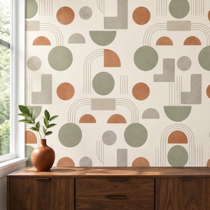 Può includere: Carta da parati con un motivo ripetitivo di forme geometriche verde salvia, arancione terracotta e grigio, tra cui cerchi, semicerchi e rettangoli, accentuato da sottili linee verticali e arcuate su uno sfondo color crema.